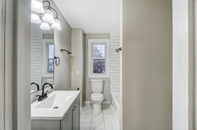 bathroom with baseboards, toilet, marble finish floor, and vanity