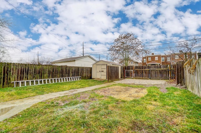 view of yard featuring an outbuilding, a fenced backyard, and a storage shed