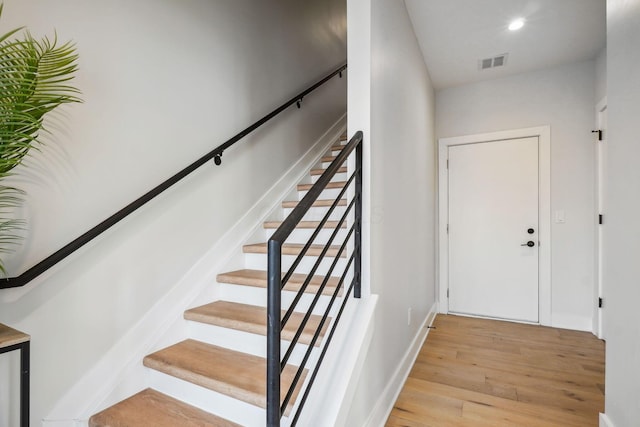 staircase with visible vents, recessed lighting, baseboards, and wood finished floors