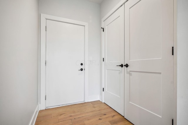 entryway with baseboards and light wood-style flooring