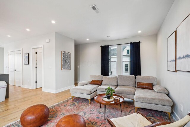 living room with visible vents, recessed lighting, light wood-style floors, and baseboards