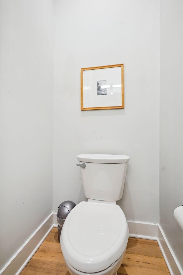 bathroom featuring baseboards, toilet, and wood finished floors