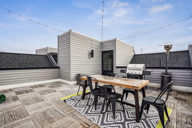 wooden terrace with outdoor dining area and a grill