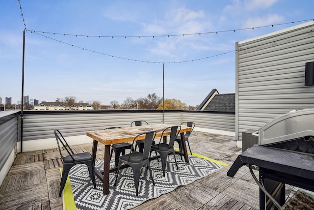 wooden terrace featuring outdoor dining area and a grill