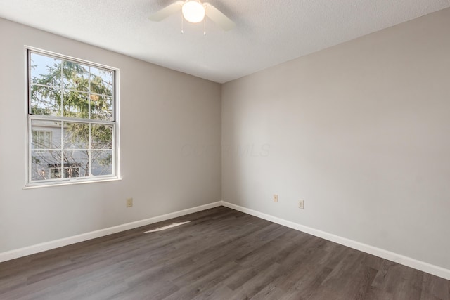 spare room with dark wood finished floors, ceiling fan, baseboards, and a textured ceiling