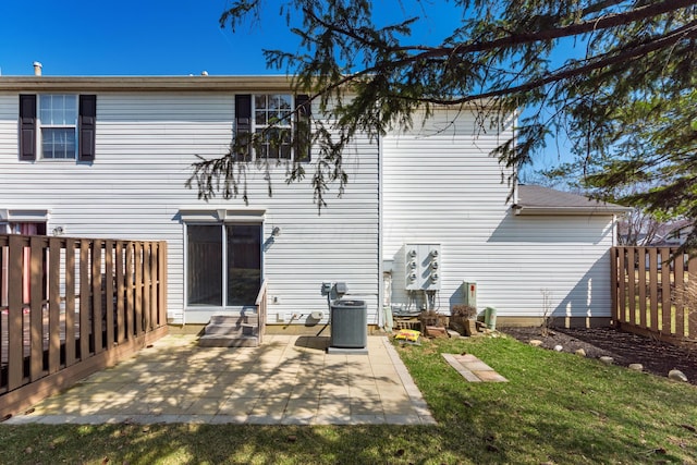 rear view of property featuring central air condition unit, a lawn, entry steps, a patio, and fence