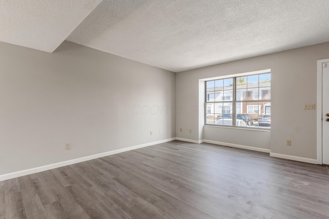 empty room featuring baseboards and wood finished floors