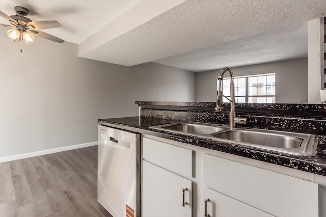 kitchen featuring baseboards, light wood finished floors, a sink, white cabinets, and dishwasher