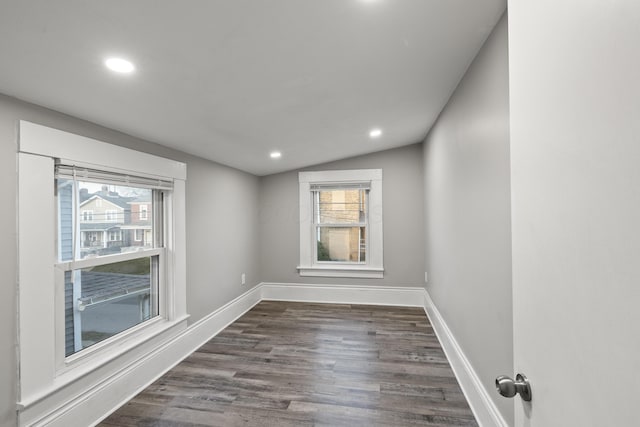 unfurnished room featuring dark wood-style floors, plenty of natural light, and baseboards