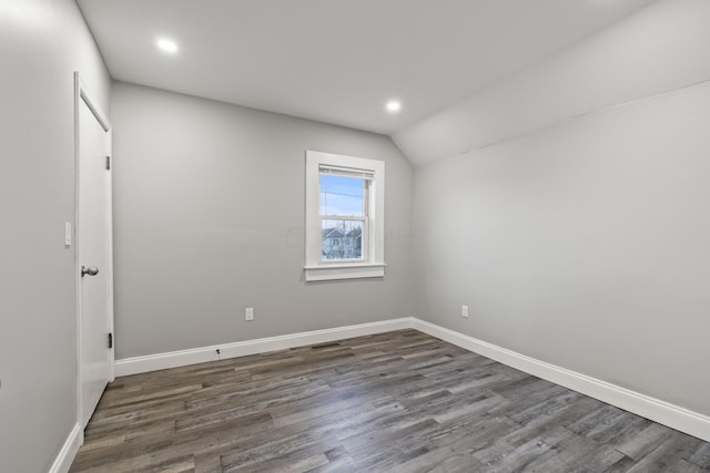 empty room with vaulted ceiling, recessed lighting, dark wood-style floors, and baseboards