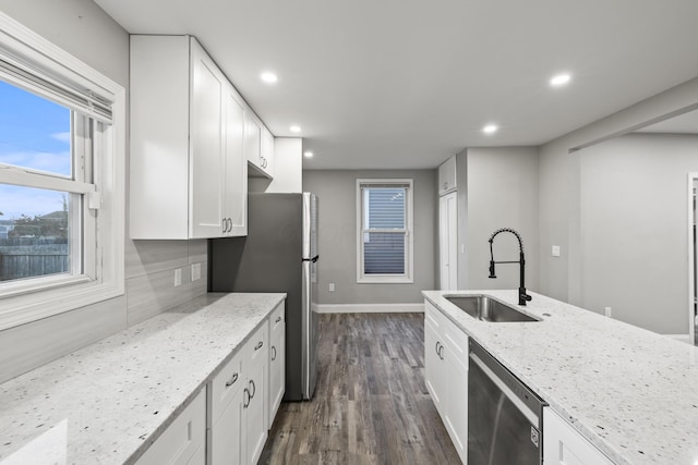 kitchen with light stone counters, recessed lighting, a sink, appliances with stainless steel finishes, and white cabinetry