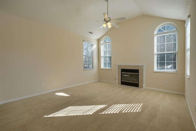 unfurnished living room with visible vents, baseboards, vaulted ceiling, carpet flooring, and a tile fireplace