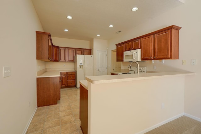 kitchen featuring white appliances, a peninsula, baseboards, and light countertops