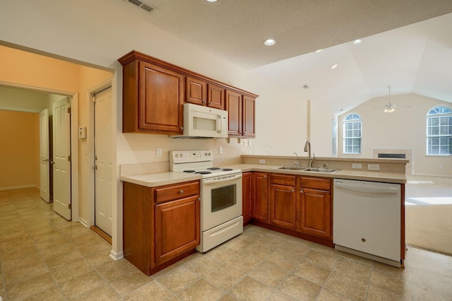 kitchen with light countertops, lofted ceiling, a peninsula, white appliances, and a sink