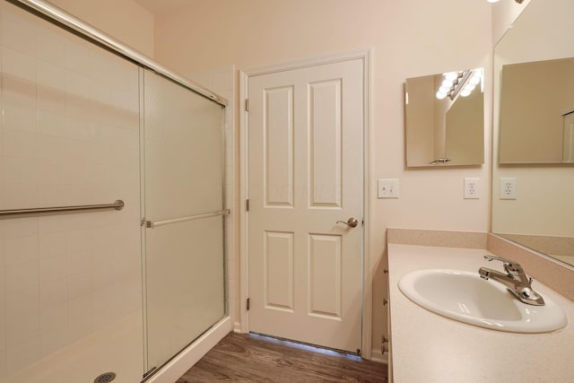 full bathroom featuring vanity, wood finished floors, and a stall shower