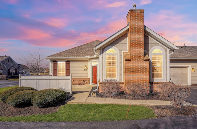 view of front of house featuring brick siding, an attached garage, a chimney, and roof with shingles