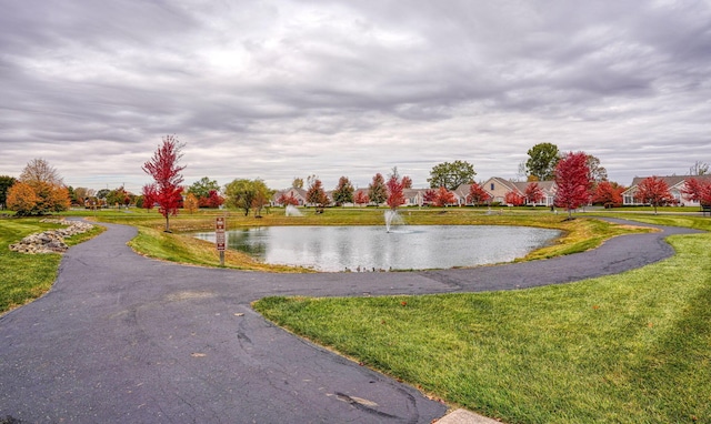 view of community with a yard and a water view