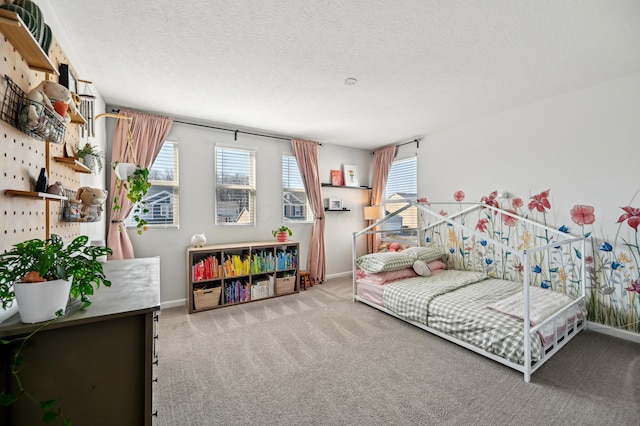 carpeted bedroom with baseboards and a textured ceiling