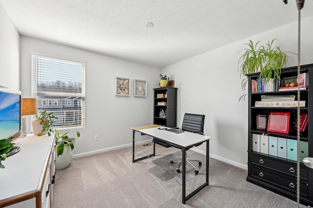 carpeted home office featuring a textured ceiling and baseboards