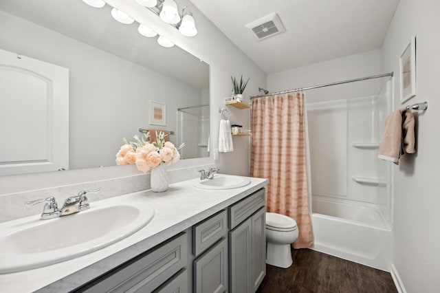 full bathroom featuring a sink, visible vents, toilet, and wood finished floors