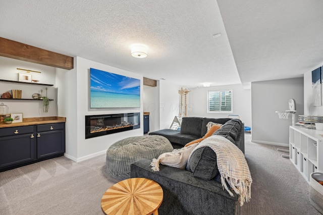 living area with a glass covered fireplace, a textured ceiling, baseboards, and light carpet