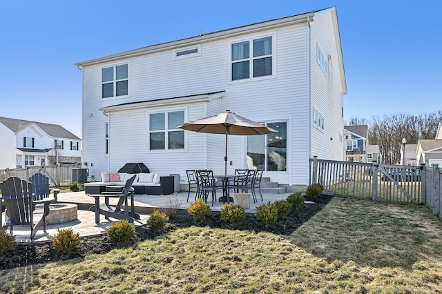 back of house featuring an outdoor living space with a fire pit, a fenced backyard, and a patio area