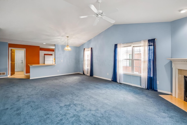 unfurnished living room featuring visible vents, a fireplace with flush hearth, vaulted ceiling, carpet floors, and a ceiling fan