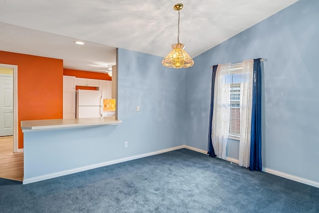 carpeted empty room with recessed lighting, baseboards, a notable chandelier, and vaulted ceiling