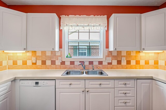 kitchen featuring a sink, decorative backsplash, light countertops, white cabinets, and dishwasher