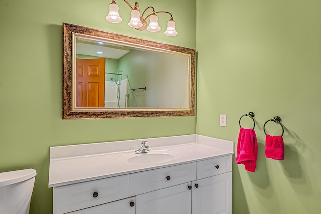 bathroom featuring toilet, vanity, and walk in shower