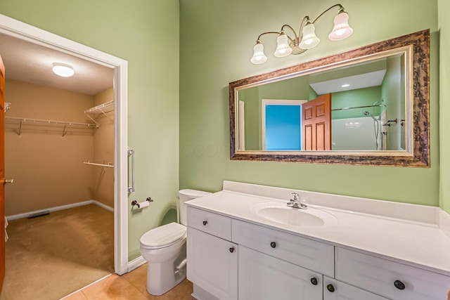 full bathroom featuring toilet, vanity, tile patterned flooring, a shower, and a spacious closet