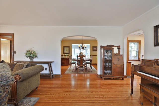 living area with arched walkways, a healthy amount of sunlight, and light wood finished floors