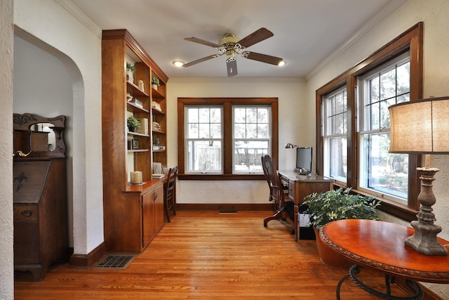 office space featuring light wood-type flooring, baseboards, ornamental molding, and a ceiling fan