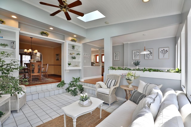 tiled living area with crown molding, recessed lighting, ceiling fan with notable chandelier, and lofted ceiling with skylight