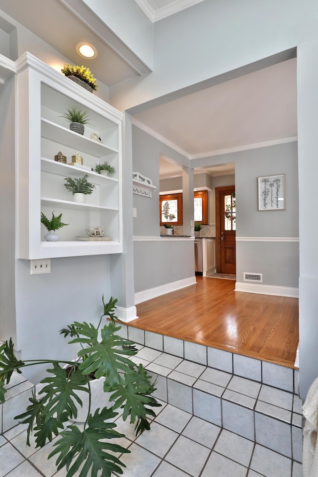 interior space featuring visible vents, baseboards, and crown molding