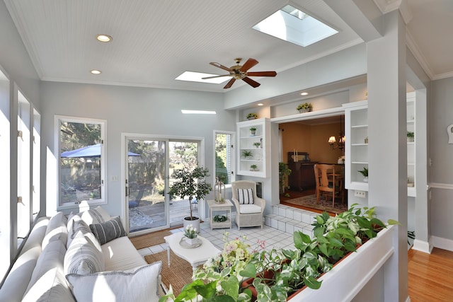 living room featuring a skylight, recessed lighting, and ornamental molding