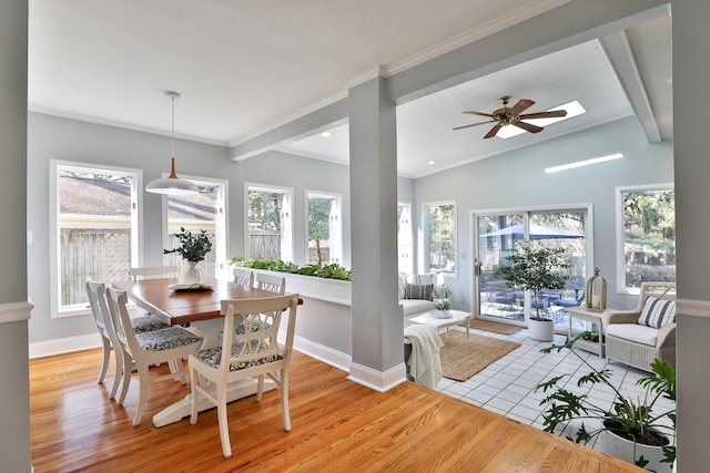 dining area featuring lofted ceiling with beams, light wood-style flooring, baseboards, and ornamental molding