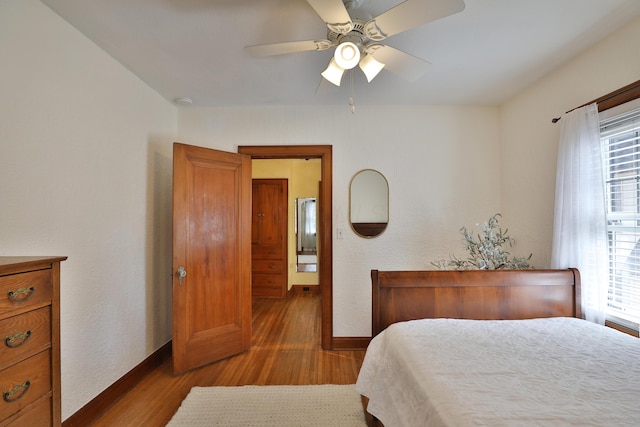 bedroom with ceiling fan, baseboards, and wood finished floors