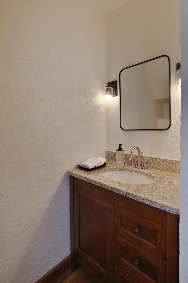 bathroom featuring vanity and a textured wall