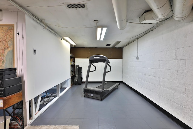 exercise room with concrete block wall and visible vents