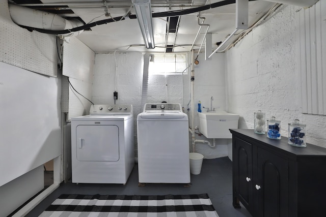 clothes washing area with a sink, separate washer and dryer, and laundry area