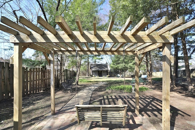 view of patio featuring an outdoor structure, a fenced backyard, and a pergola