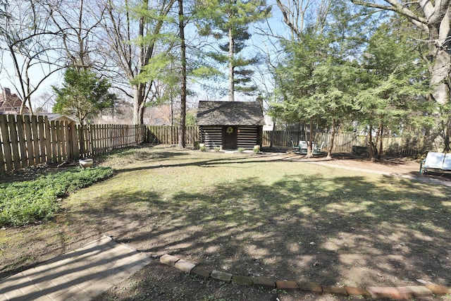 view of yard with an outbuilding, a fenced backyard, and a shed