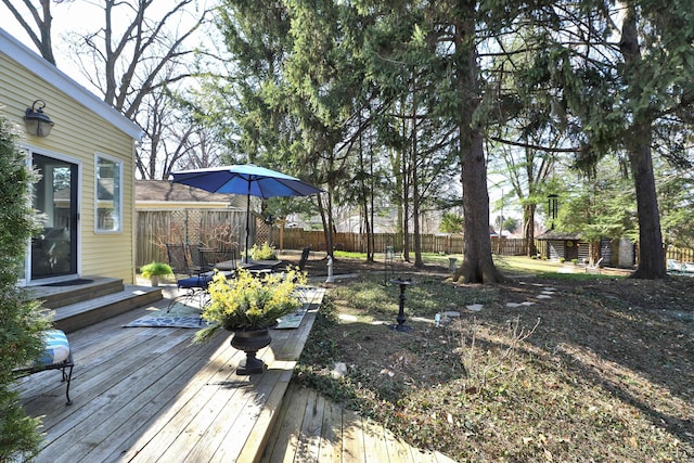 view of yard with a storage shed, an outdoor structure, a fenced backyard, and a wooden deck