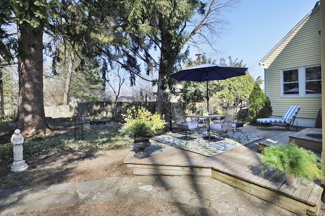 view of yard featuring a deck, outdoor dining area, and fence