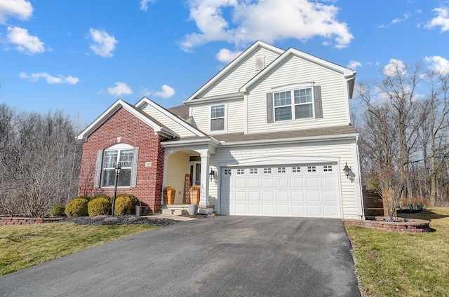 traditional-style home featuring a front yard, brick siding, an attached garage, and driveway