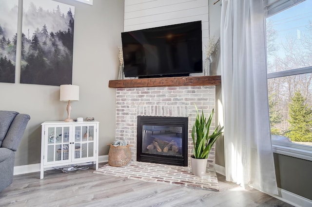 interior details featuring a fireplace, baseboards, and wood finished floors