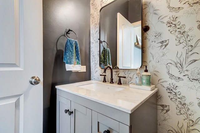 bathroom featuring vanity and wallpapered walls