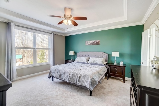 bedroom with light carpet, crown molding, and a tray ceiling