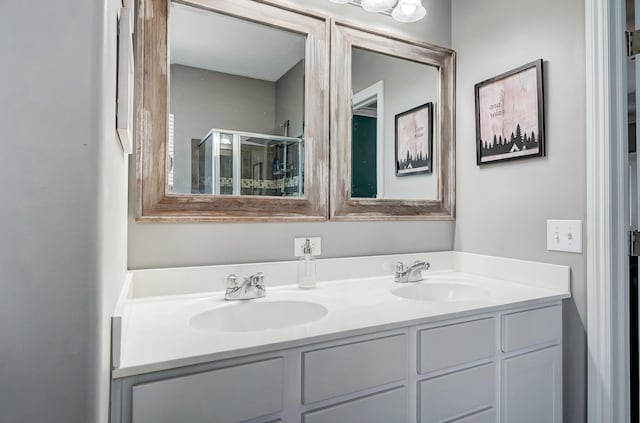 bathroom featuring a sink, a shower stall, and double vanity